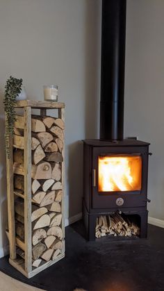 a wood burning stove next to a stack of logs