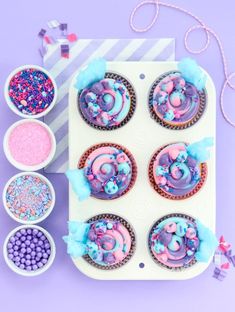 the cupcakes are decorated with pink and blue icing