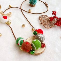 the necklace is decorated with colorful balls and beads on it's cord, along with other ornaments