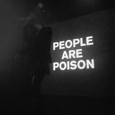 the words people are poison projected on a wall in black and white with light coming from behind it