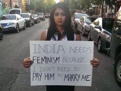 a woman holding a sign that says india needs feminism because i don't need to pay him to marry me