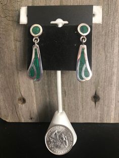 Malachite and Sterling Silver Earrings Southwestern Beautiful green Malachite is inlayed into Sterling Silver to create these gorgeous Southwestern-style earrings. The earrings come in two pieces connected together to create an attractive dangle drop style. These gorgeous earrings are finished off with post backs. They are stamped on the backs with the artisan's number, 925 (Sterling) and Mexico, denoting their country of excellent craftmanship. Length: 1-1/2 inches Width: 1/2 inch Weight: 12 gr Green Malachite, Southwestern Style, Style Earrings, Gorgeous Earrings, Two Pieces, Belly Button Rings, Sterling Silver Earrings, Silver Earrings, Seattle