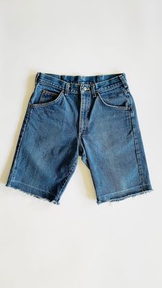 "High rise denim shorts with fly front opening, 5 pockets and a frayed raw hem. 100% cotton. Waist: 15\" Hips: 20\" Rise: 11\" Inseam: 10\" Hem: 9.5\"" Denim Blue Jean Shorts With Frayed Hem, Distressed Dark Wash Cotton Shorts, Denim Blue Cutoff Shorts With Frayed Hem, Medium Wash Straight Leg Cotton Shorts, Relaxed Fit Jean Shorts With Frayed Hem, Dark Wash Relaxed Fit Knee-length Jean Shorts, Straight Leg Medium Wash Cotton Shorts, Straight Leg Cotton Shorts In Medium Wash, Medium Wash Jean Shorts With Frayed Hem