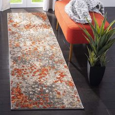 a living room with an orange couch and rug on the floor next to a window