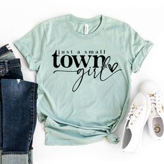 "Just A Small Town Girl T-shirt, Country Girl Shirt, Country Music Gift, Young Woman Tee, Boho Top, Christmas Shirt, Jesus Gift, Country Girl Shirt, Young Woman Shirt, Country Shirts Women, Southern Girl Shirt, Farm Shirt, Cowgirl Shirt, Small Town Shirt, Country Music Shirt, Texas Girl Shirt, Country Shirts, Funny Womens Shirt, Western Shirt, Gifts For Girlfriend This updated unisex essential fits like a well-loved favorite. Super soft cotton and excellent quality print makes one to fall in love with it over and over again. ------------- Fabrication ------------- 100% Combed ring spun cotton Made by specially treating the cotton fibers before spinning them into yarn. The result is stronger and smoother fabric. ------------- Unisex T-shirt Size Chart ------------- XS - - 27\" Length and 18 Vacation Tee Shirts, Outdoor Tshirt, Jesus Gift, Gift For Bff, Just A Small Town Girl, Country Music Shirts, Beach Tee