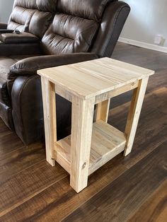 a wooden table sitting on top of a hard wood floor next to a recliner