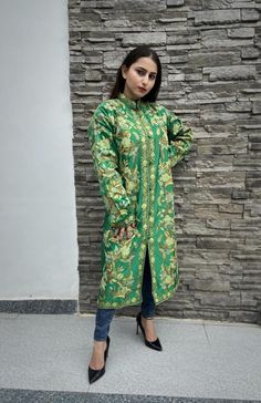 Get a polish look with this jacket. Pair it up with a skirt, trousers, dress or even a flowing maxi and be ready in style.Product Details- Condition: Brand New (made to order)- Handmade- Style: Coat- Fabric: Art Raw Silk/Pure Raw Silk/Wool- Embroidery: Kashmiri Aari Embroidery- Base Color: Green- Embroidery Color: Multi-Color- Fully Lined from Inside- Features Pockets on both sides- Length: 42" (107 cms approx)- Care Instructions: Dry Clean Only**If you want the coat to be shorter or longer, sen Long Green Jacket, Skirt Trousers, Coat For Woman, Boho Shawl, Embroidered Coat, Green Embroidery, Wool Embroidery, Aari Embroidery, Women Coat