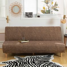 a living room with a futon and zebra rug