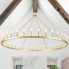 a chandelier hanging from the ceiling in a room with white walls and wood beams