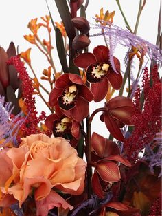 an arrangement of flowers and foliage in a vase