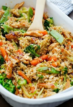 a white bowl filled with rice, broccoli and carrots