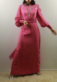 Vintage 70s pink maxi evening dress with voile big sleeves and hight cuffs. Silver geometric decoration. Comes with a extra long voile scarf. Best fit size 10 uk Shoulder to shoulder 37 cm Cheat 42 cm Waist 38,5 cm Hips 50 cm Length 141 cm Model's size 6 UK, h 163 cm Excellent vintage conditions. Shipping of this item takes one week for dry cleaning. I wish the dress is perfect for you! All items are vintage and used. However they are all in good to excellent condition. Any defect is specified. Long Pink Party Dress, Pink Long Sleeve Maxi Dress For Evening, Pink Long Party Dress, Pink Floor-length Party Abaya, Pink Long Sleeve Maxi Dress For Banquet, Pink Long Sleeve Evening Dress For Banquet, Long Sleeve Pink Evening Dress For Banquet, Festive Long Pink Abaya, Pink Long Maxi Dress For Eid