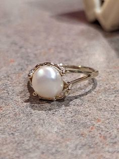 a white pearl ring sitting on top of a table