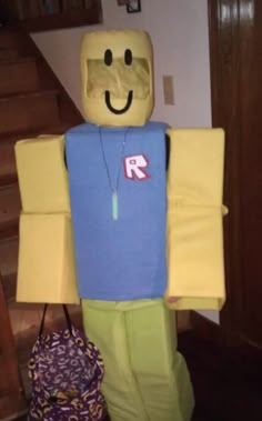 a paper mache is standing next to a handbag on the floor in front of stairs