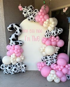 the balloon arch is decorated with pink, white and black balloons that spell i'm two