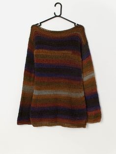 a sweater hanging on a hanger with the colors of brown, blue and green