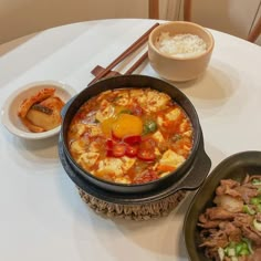 a table topped with two bowls filled with food