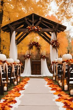 an outdoor ceremony set up with candles and fall leaves on the aisle, decorated with pumpkins