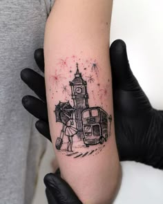 a person with a tattoo on their arm holding an umbrella in front of a clock tower