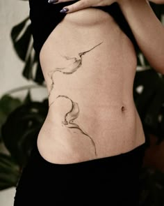 a woman's stomach with a bird tattoo on her belly and the bottom part of her lower body