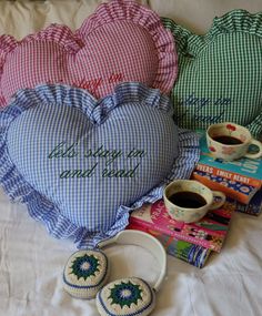 a heart shaped pillow, coffee mug and other items on a bed