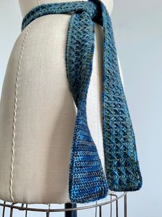 a crocheted blue scarf on top of a mannequin