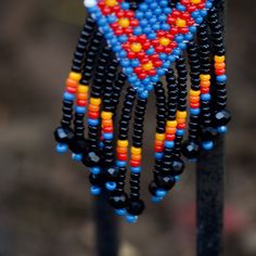 beaded earrings hanging from a metal pole