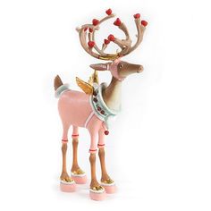 a pink and gold reindeer figurine with red berries on its antlers, standing against a white background