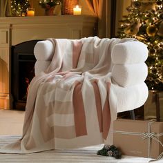 a white chair covered in a blanket next to a christmas tree