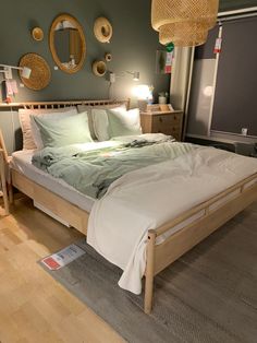 a large bed sitting in a bedroom next to a wooden dresser and lamp on top of a hard wood floor