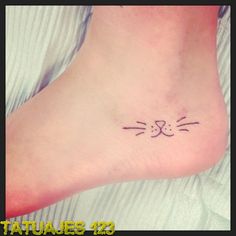 a small cat's face tattoo on the foot