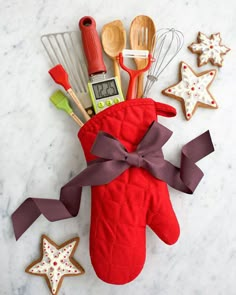 an oven mitt decorated with kitchen utensils and star shaped cookie cutters