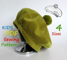 a green hat with pom - poms sitting on top of a metal stand