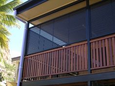 a wooden balcony next to a palm tree