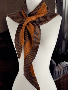 a white mannequin with a brown and black scarf on it's neck