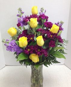 a vase filled with yellow and purple flowers