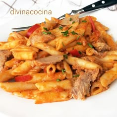 a white plate topped with pasta and meat