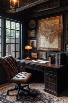 an old world map hangs on the wall above a desk with a chair and lamp