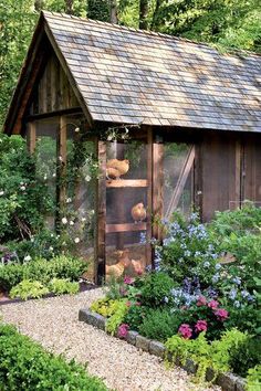 a garden shed with flowers and plants around it