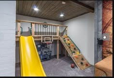 a play area with a slide, basketball hoop and climbing wall in the basement for kids