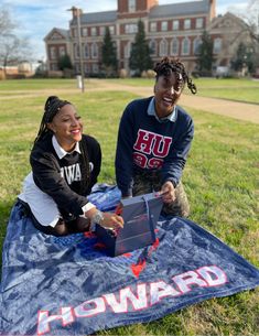 two young people sitting on the ground with a blanket in front of them that says howard