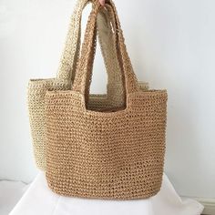 Beachy Sand-colored Straw Bag, Sand-colored Straw Bag For Summer Beach, Beachy Sand-colored Beach Bag With Braided Handles, Spring Beach Sand-colored Straw Bag, Summer Style Sand-colored Shoulder Bag, Summer Sand-colored Straw Bag, Basket Beach Bag Made Of Natural Fiber For Vacation, Eco-friendly Open Weave Straw Bag For Summer, Chic Lightweight Beige Straw Bag