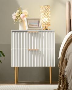 a white and gold dresser with flowers on top