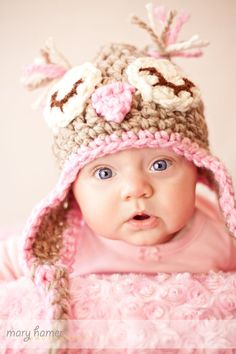 a baby wearing a crocheted hat with flowers