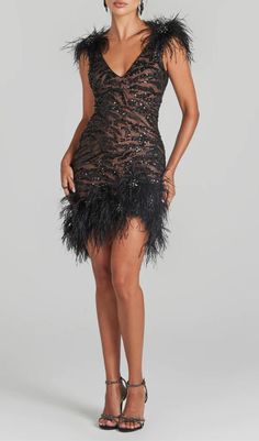 a woman in a black dress with feathers on it