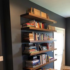 a bookshelf filled with lots of books next to a window in a room