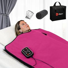 a woman laying on top of a bed with a pink blanket and remote control in front of her