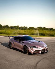 a pink sports car parked in a parking lot