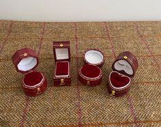 three small red boxes sitting on top of a brown carpeted floor next to each other