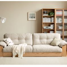 a living room with a white couch and bookshelf